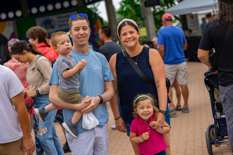 A family of 4 stand together in downtown Grand Forks at the Town Square Farmers market.