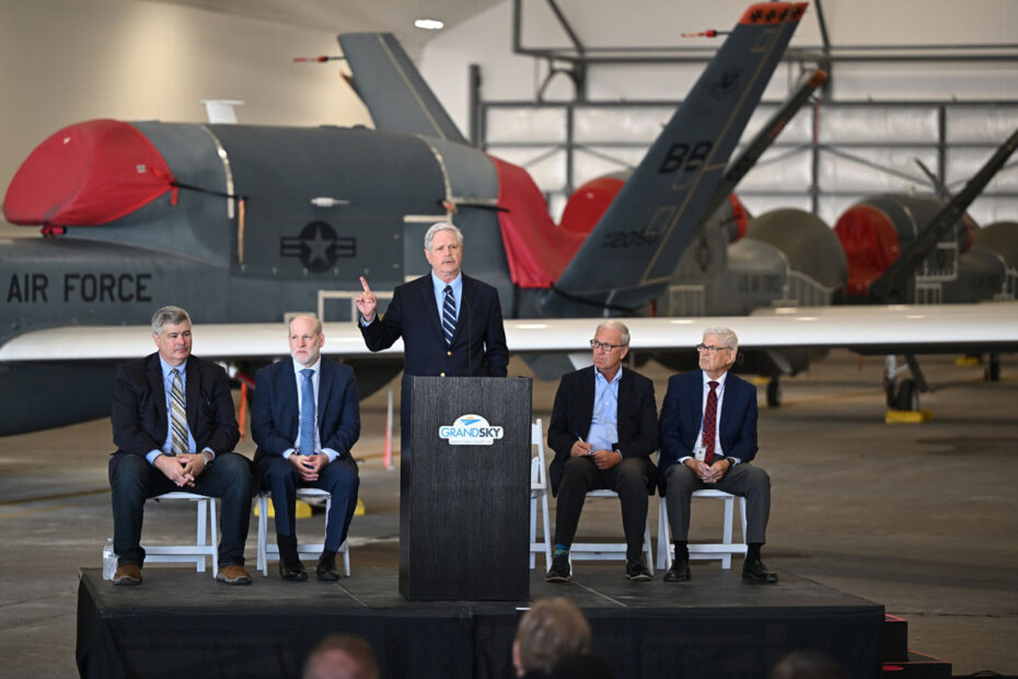 Senator John Hoeven stands at a podium addressing a crowd of people at Grand Sky in Emerado North Dakota.