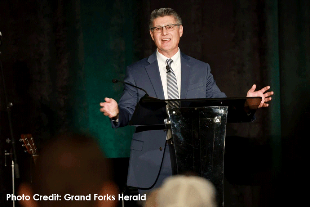 Dr. Terry Brenner stands on stage at the Report to the Community Breakfast on October 25th.