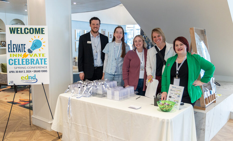 Kevin Hatcher, Michaela Kauk, Laura Lacher, Dana Hager, and Becca Cruger stand together at the check in table for the 2024 EDND Spring Conference.