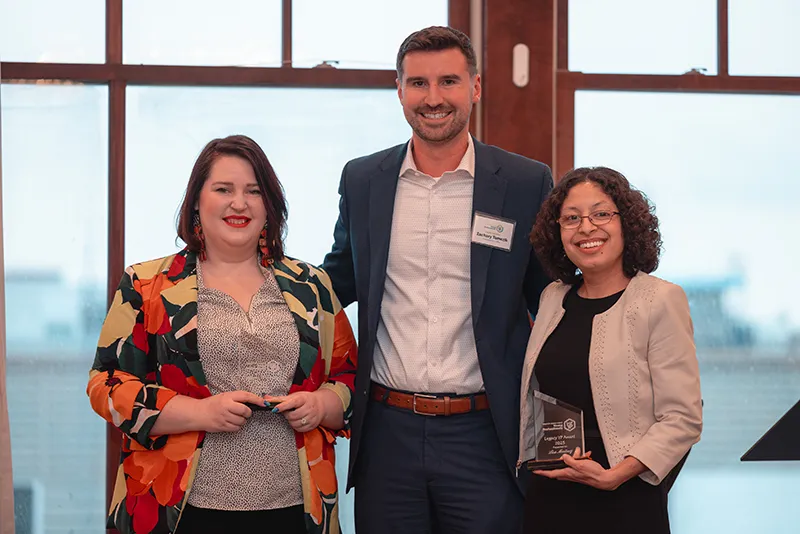 Three community leaders standing with the Greater Grand Forks Young Professionals Legacy Award.