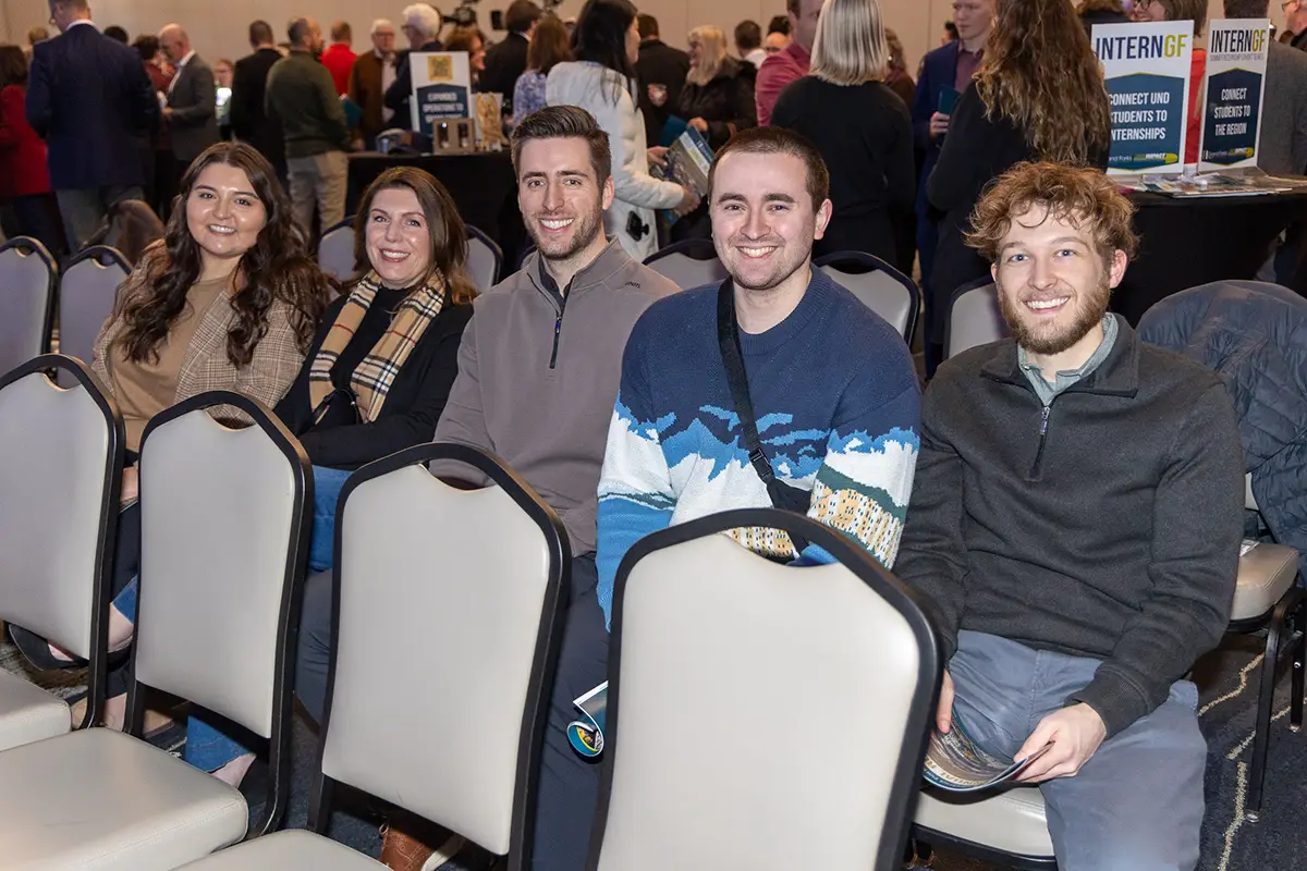 A group of AE2S employees sit together at the annual meeting.