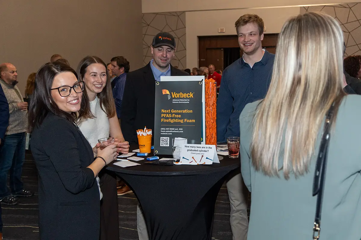 The Vorbeck staff stands together at a cocktail table at the 2026 Annual Meeting social.