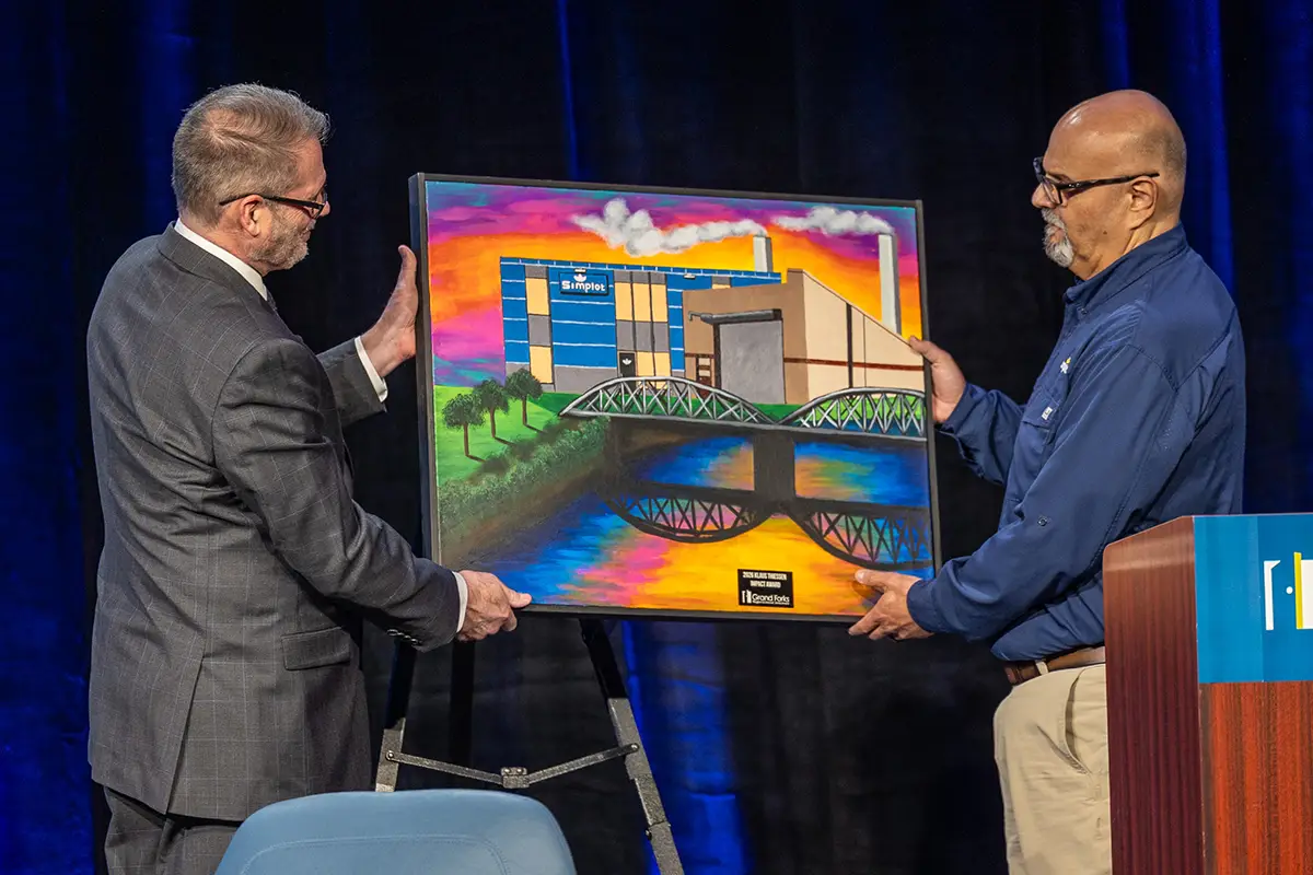 EDC president & CEO keith lund presents the 2026 impact award artwork to simplot unit director David Valdez.
