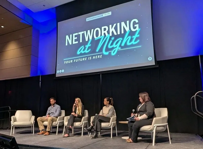 Participants of a Networking at Night panel sit at a fireside chat on stage.