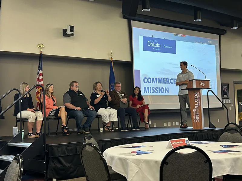 Economic development professionals sit on stage speaking on a panel about economic development and business in North Dakota at Developer Day in Bismarck in August 2024.