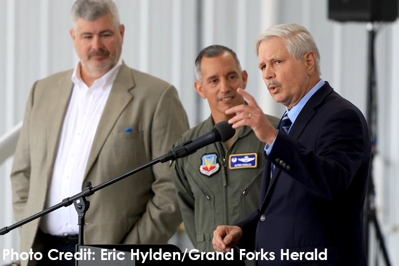 U.S. Sen. John Hoeven (right) announces a $100 million contract ceiling extension for project ULTRA that will allow expansion of UAS operations at GrandSky at an event Friday, July 18, 2025, at GrandSky, near Grand Forks Air Force Base. At left is Tom Swoyer, founder and president of GrandSky, and Col. Alfred Rosales, commander, 319 Reconnaissance Wing, Grand Forks Air Force Base.